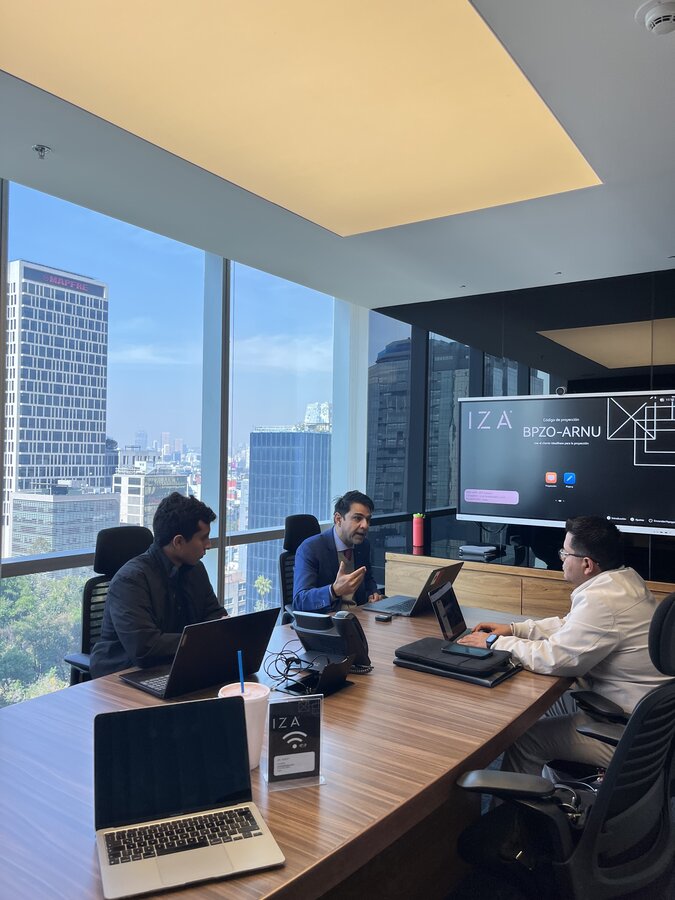 Ashish in session with a cohort, Mexico City skyline through the windows
